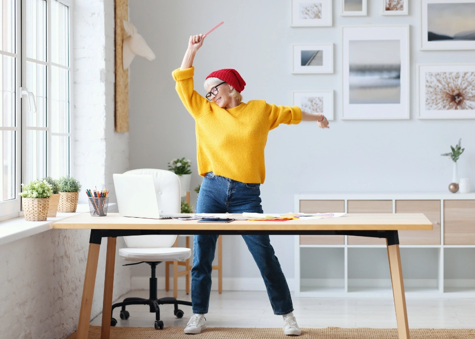 Une femme heureuse danse près de son bureau